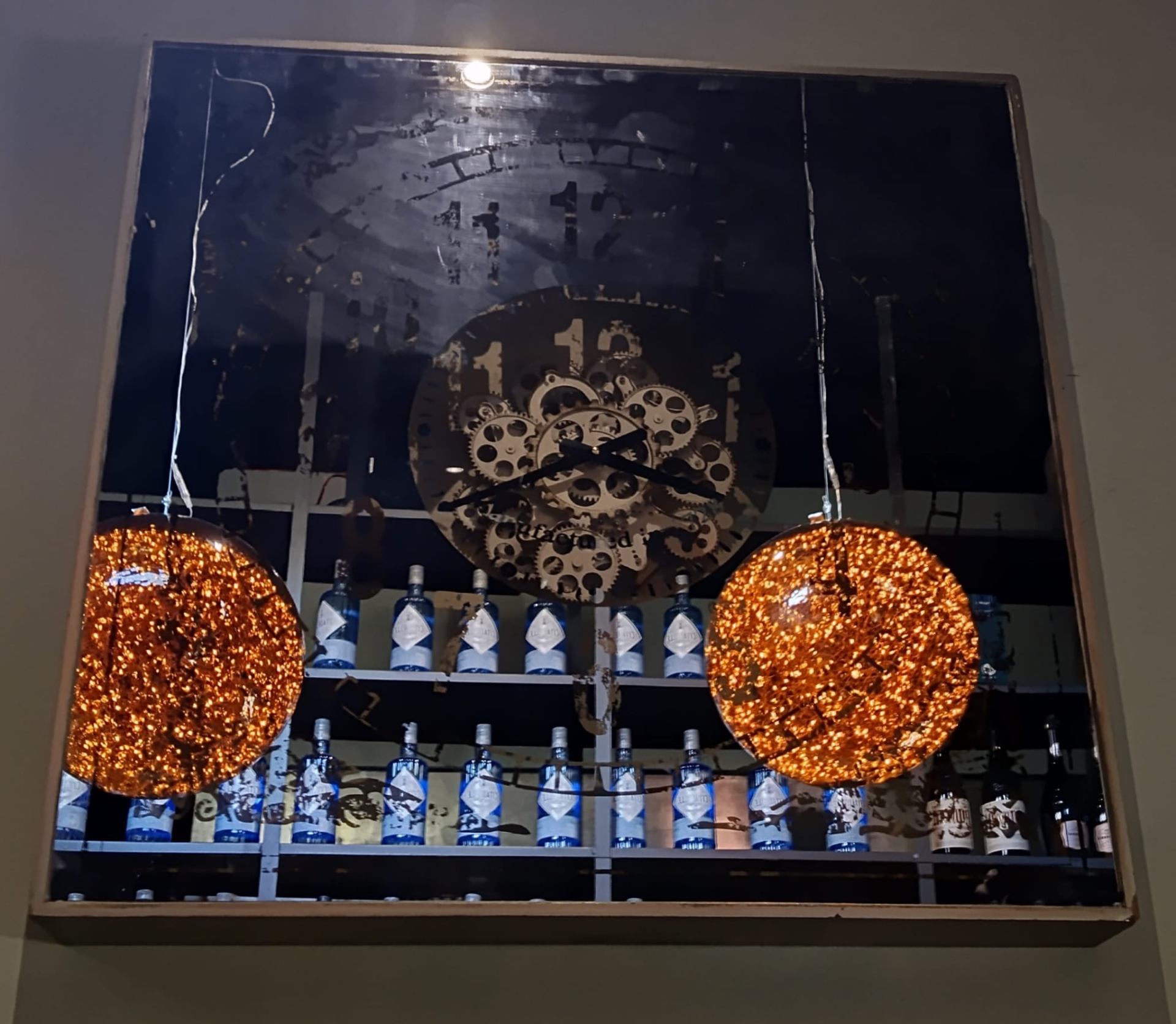 Reloj de engranajes decorativo sobre el botellero