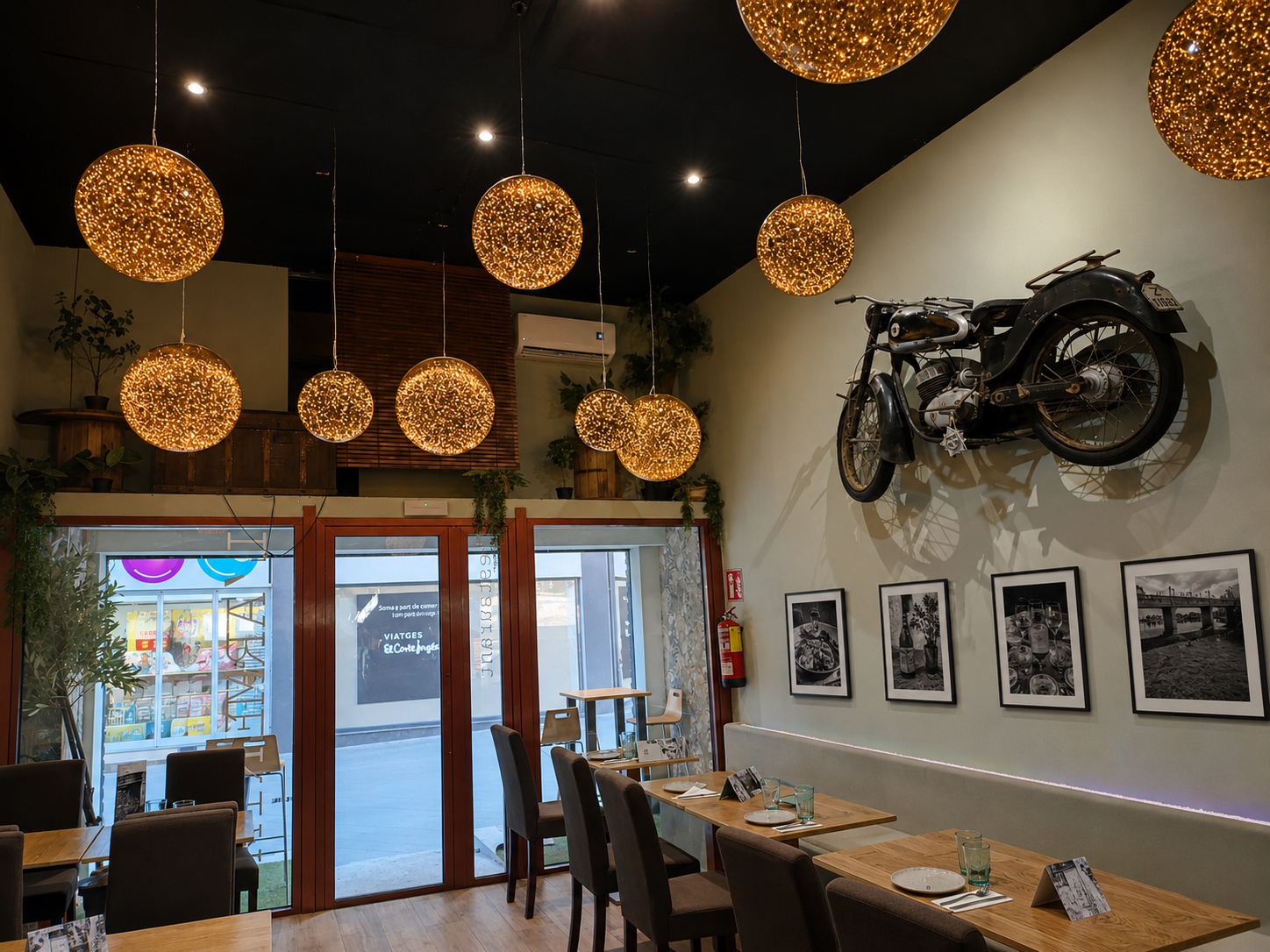 Sala principal de L'Armeria con lámparas doradas y motocicleta vintage